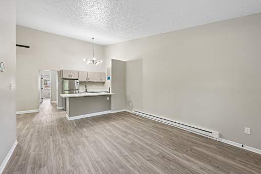 A kitchen area with a refrigerator, cabinets, and a countertop.
