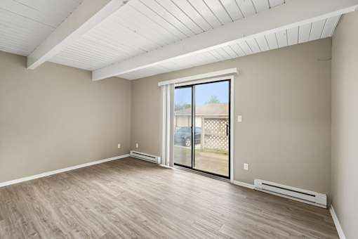 A room with a sliding glass door leading to a balcony.