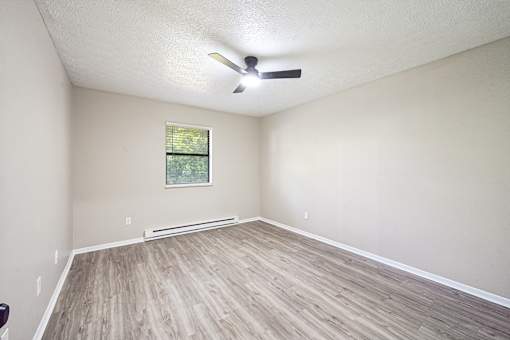 A room with a ceiling fan and a window.