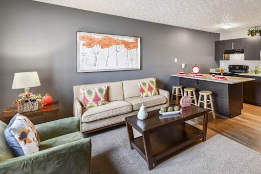 A living room with a couch, a coffee table, and a painting on the wall.