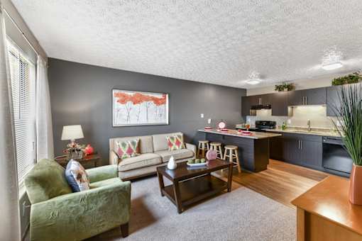 A living room with a green chair and a painting on the wall.