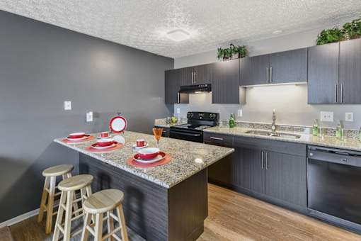 A kitchen with a granite countertop and bar stools.