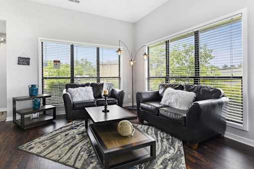 A living room with a black couch and a coffee table.