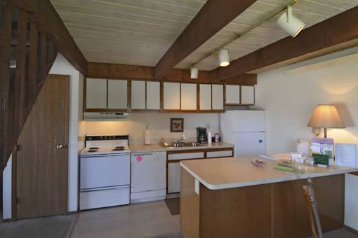A kitchen with white appliances and wooden cabinets.