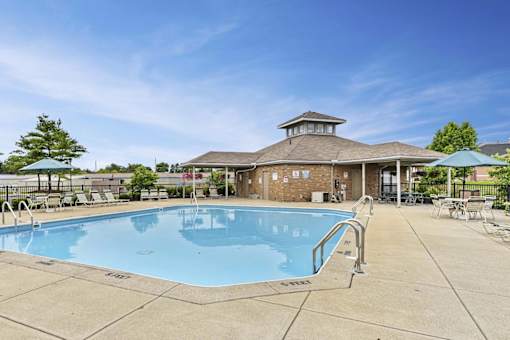 A large outdoor swimming pool with a pavilion in the background.