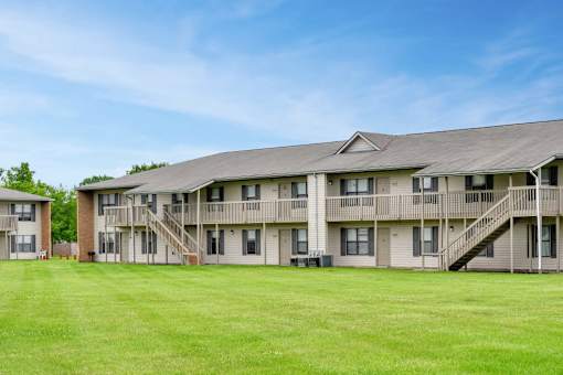 A large grassy field in front of apartment buildings.