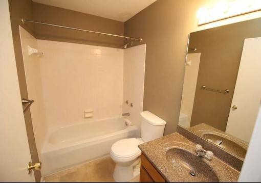 A bathroom with a toilet, sink, and bathtub.