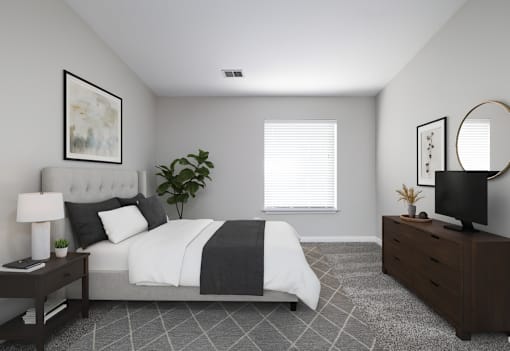 A bedroom with a bed, nightstand, and a plant.