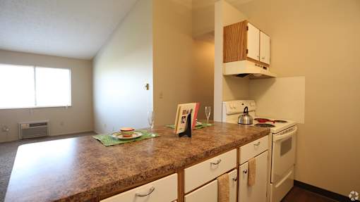 A kitchen with a brown counter top and white cabinets.