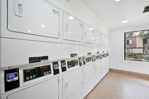 a white utility room with white appliances and a window