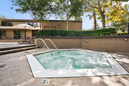 a hot tub in a backyard with a house in the background