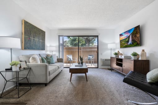 a living room with a couch and a coffee table and a large window