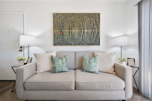 a living room with a couch and a painting on the wall
