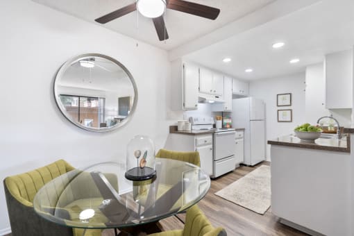 a white kitchen and dining room with a glass table