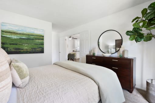 a bedroom with a bed and a dresser and a mirror