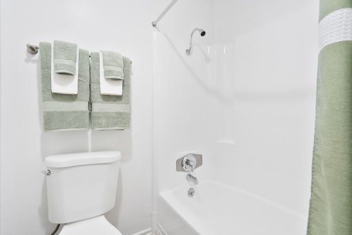 a bathroom with a shower and a toilet and towels