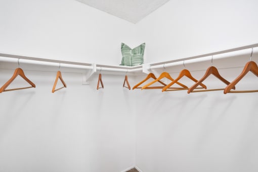 a closet with wooden clothes hangers and a metal angel on the wall