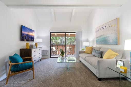 a living room with a gray couch and a glass coffee table