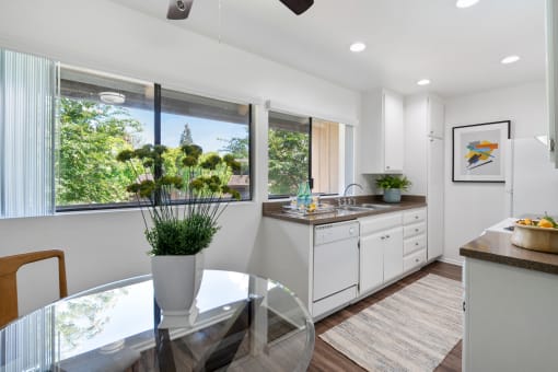 a kitchen with white cabinets and a glass table