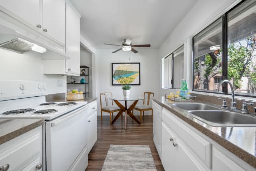 a kitchen with white cabinets and a sink and a window