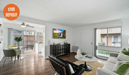 A living room with a black chair and a coffee table in the foreground.