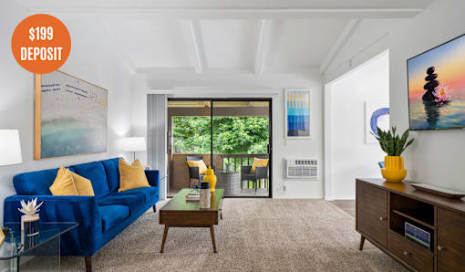 A living room with a blue sofa and a poster on the wall.