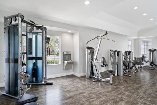a gym with weights and cardio equipment in a home with a window