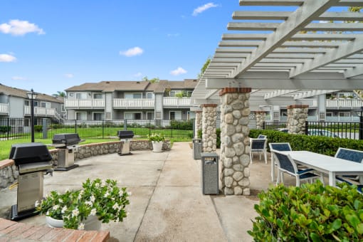 an outdoor patio with tables and chairs and a grill