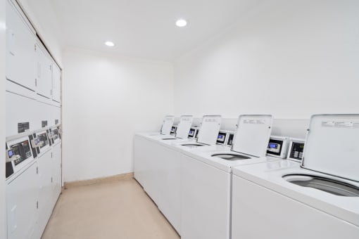 a washer and dryer room with white appliances and white walls
