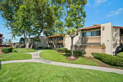a building with trees and a sidewalk in front of it
