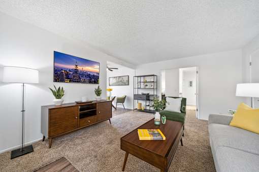 A living room with a flat screen TV mounted on the wall.