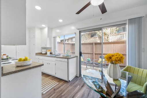 an open kitchen and dining area with a glass table and chairs