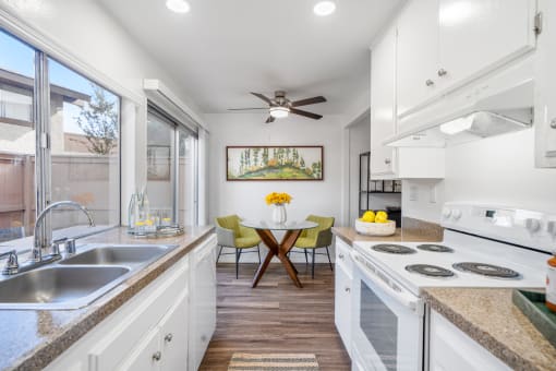 a kitchen with white cabinets and a counter top and a sink