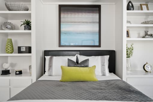 a bedroom with white walls and a bed with a lime green pillow