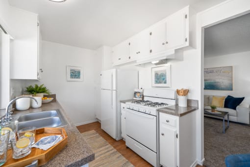 a kitchen with white appliances and a counter top and a sink