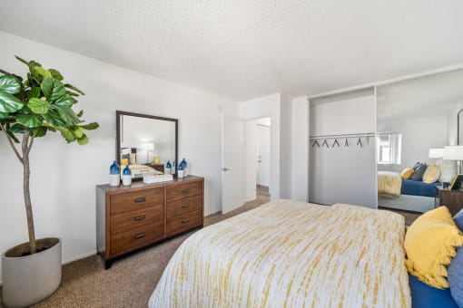 a bedroom with a bed and a dresser with a mirror