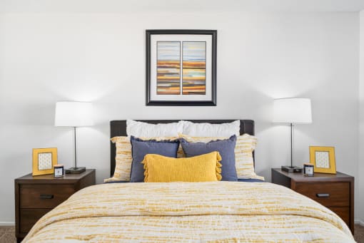 a bedroom with a bed with yellow and blue pillows
