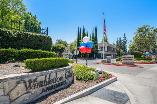 a welcome sign with balloons and an american flag in front of a building