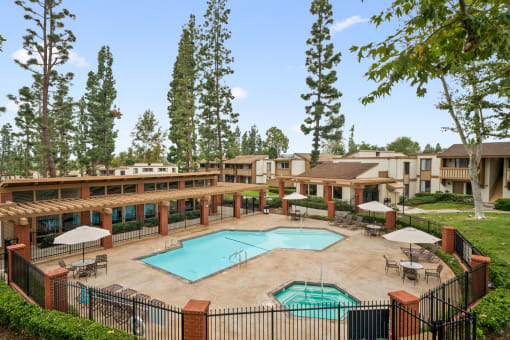 a courtyard with a pool and buildings with trees