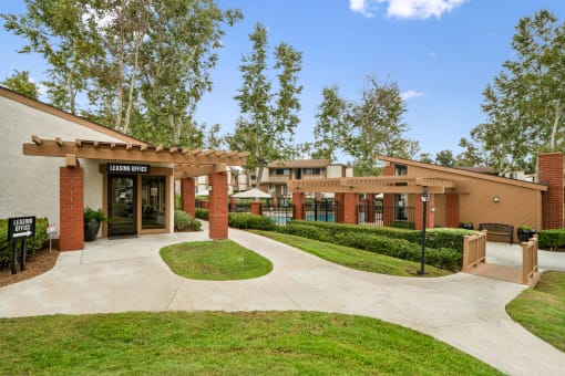 a building with a sidewalk and trees in front of it