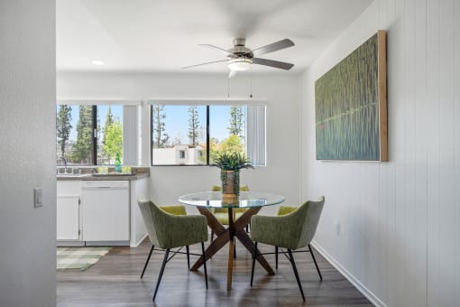 a dining room with a table and chairs and a ceiling fan