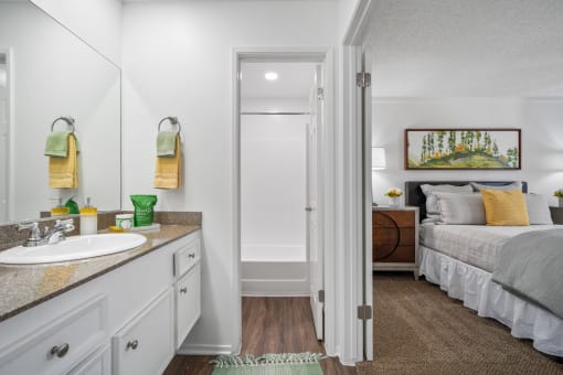 a bathroom with a sink and a bedroom with a bed