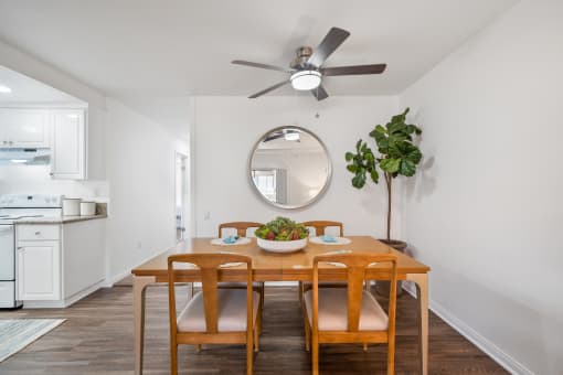 a dining room with a table and chairs and a ceiling fan