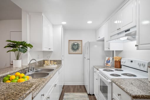 a kitchen with white cabinetry and granite countertops