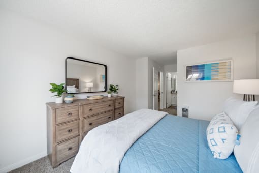 a bedroom with a large bed and a dresser with a mirror