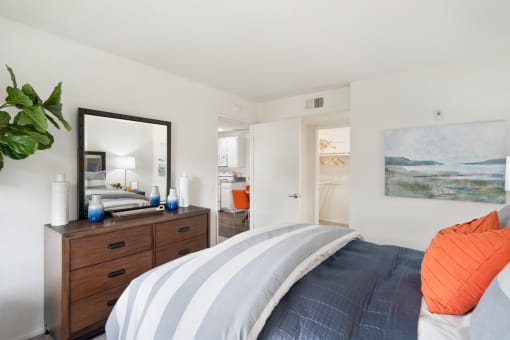 a bedroom with a bed and a dresser and a mirror
