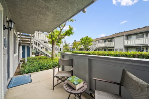 a balcony with two chairs and a table on a balcony