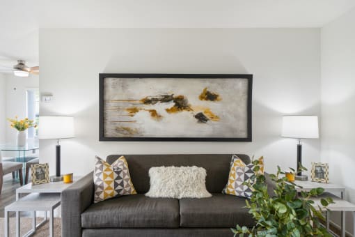 a living room with a couch and a painting on the wall