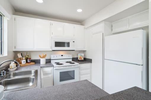a white kitchen with white appliances and white cabinets