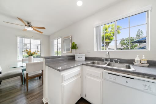 a kitchen with white cabinets and a stainless steel counter top